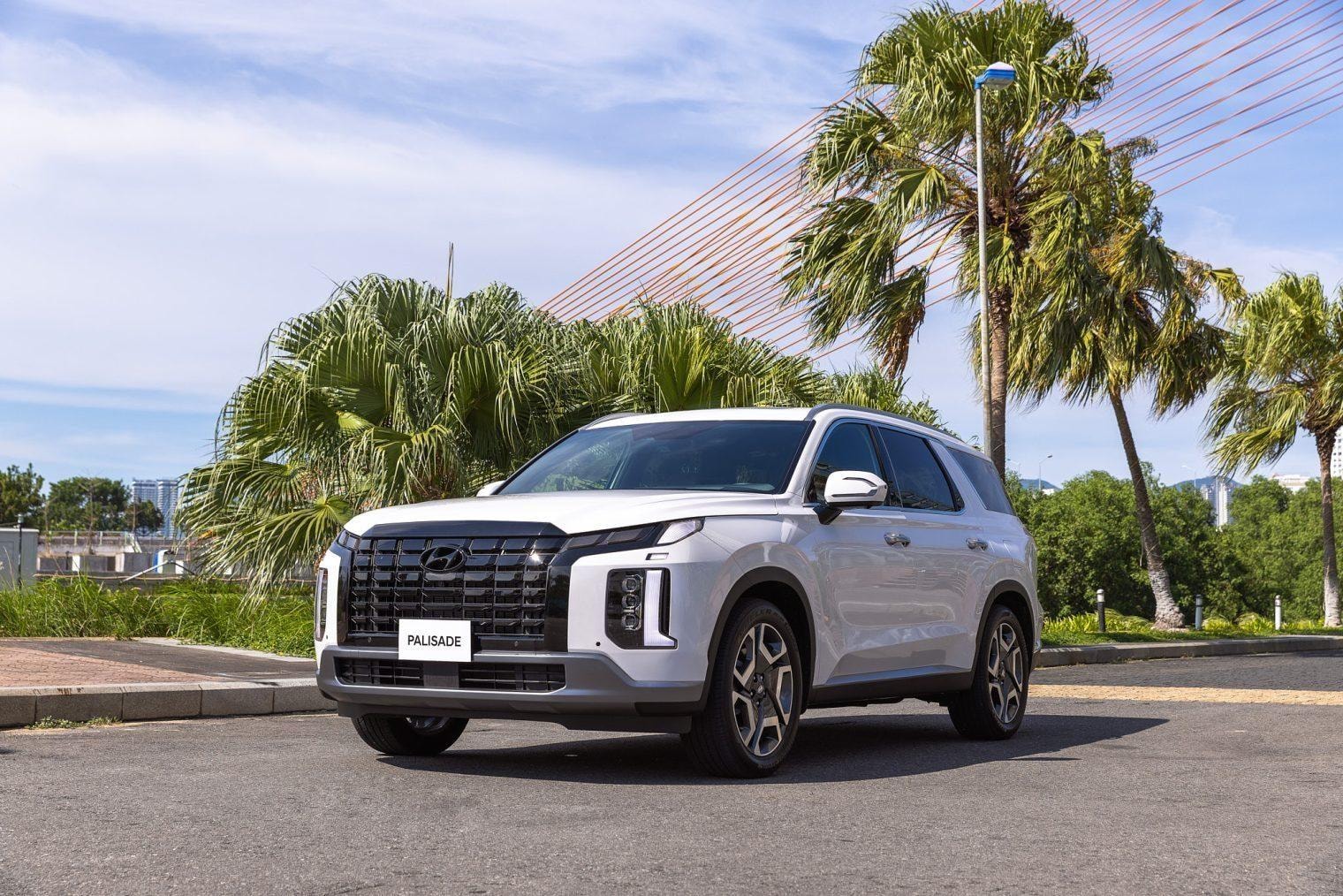 Hyundai Palisade màu trắng nhìn chéo từ phía trước trong cảnh quan đô thị